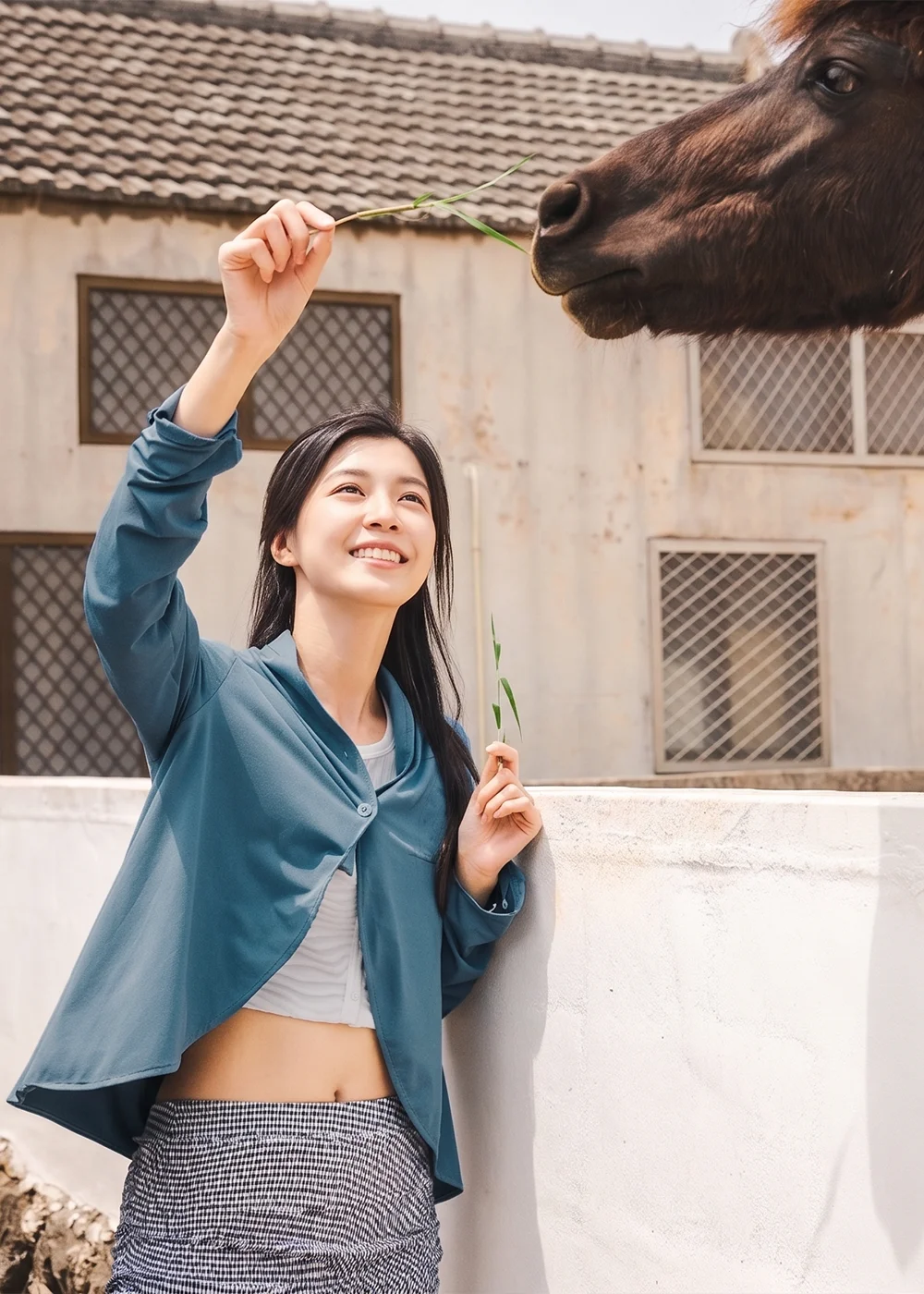 女性模特兒穿著輕薄涼感抗菌防曬外套,在戶外農場餵馬體驗休閒旅遊防曬穿搭
