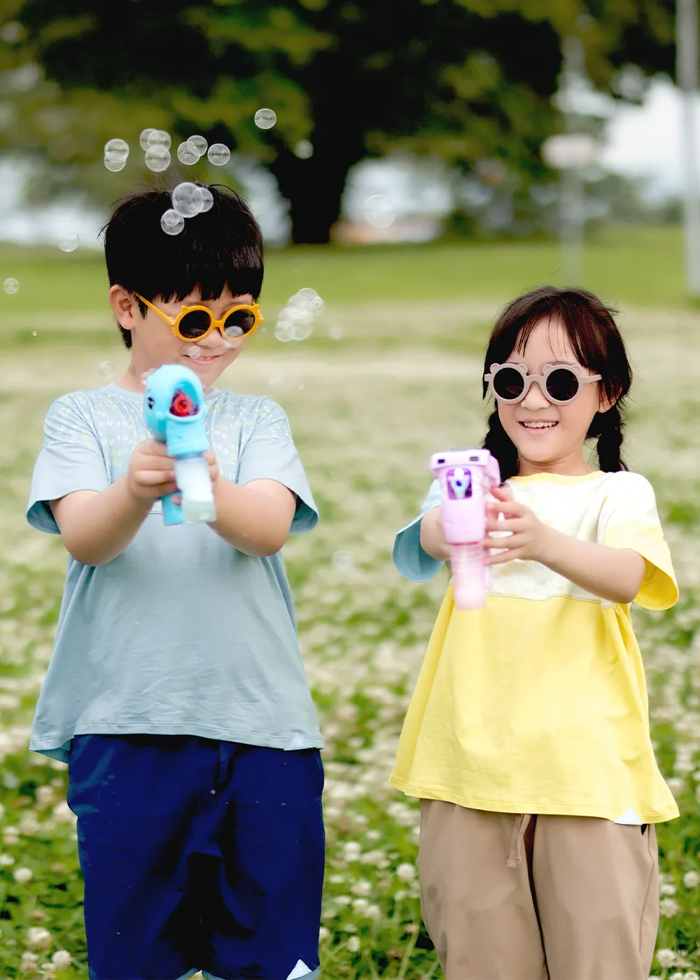 兒童防曬T恤穿搭,小孩戴墨鏡穿著UV100透氣涼感上衣在公園開心玩泡泡槍