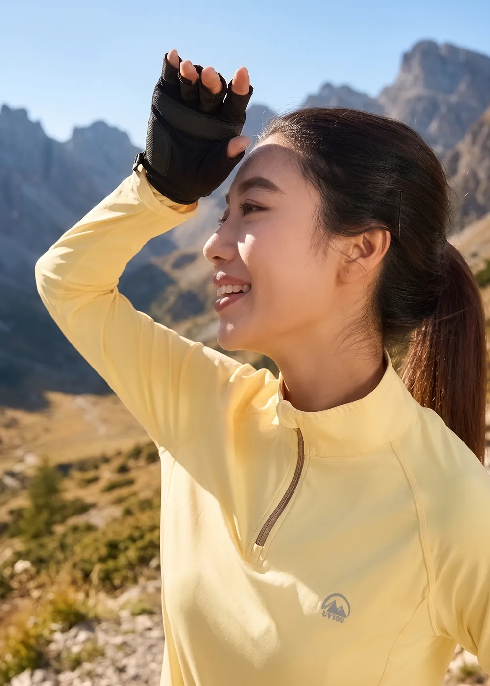 登山步道上女性穿著機能防曬衣與半指防曬手套遮擋強光陽光的高山旅遊情境