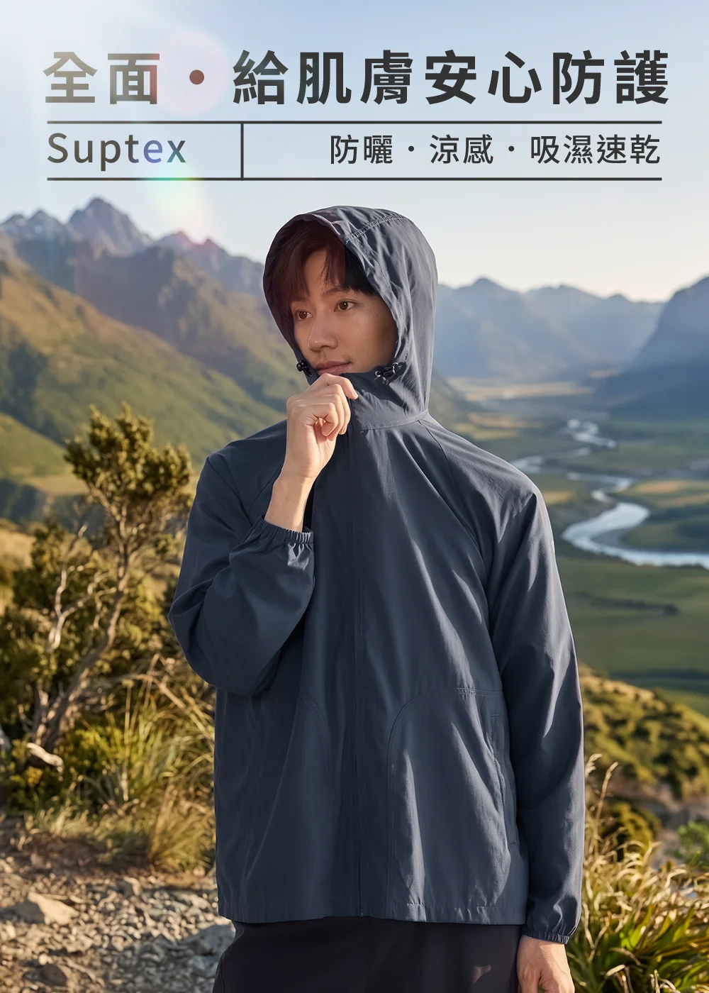 Suptex全面肌膚安心防護情境,男模特兒身穿深藍色防曬連帽外套置身壯麗高山背景,展現防曬、涼感、吸濕速乾的高山機能穿搭