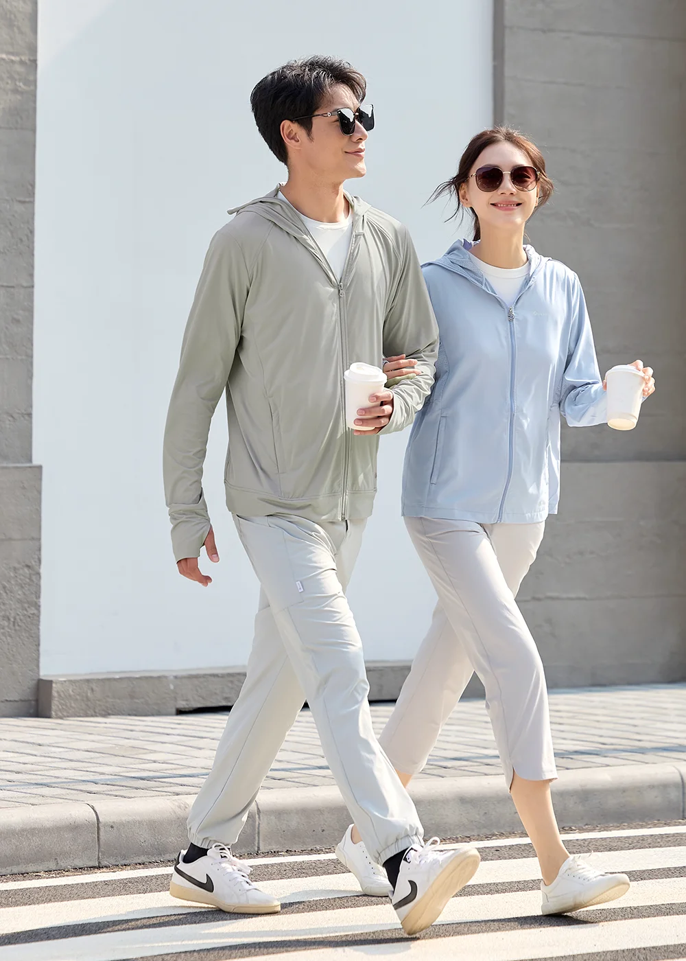 Apex 都會防曬涼感外套系列,男女模特兒示範淺灰色與淺藍色情侶穿搭,具備吸濕速乾功能,適合城市休閒走動。