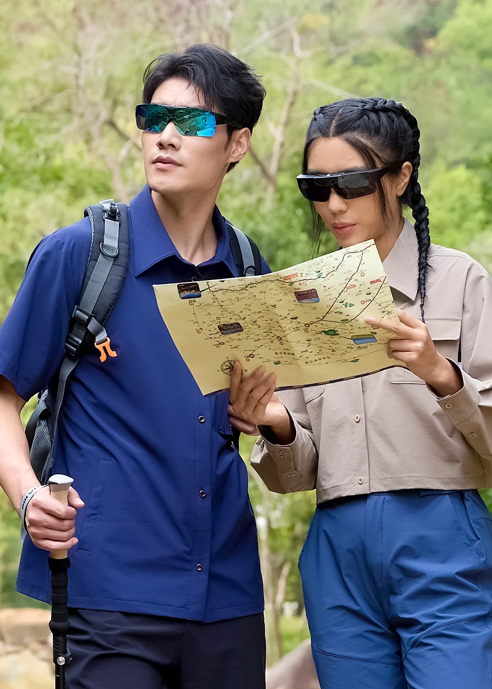 男女登山穿搭:展示不同顏色(藍、黑鏡片)的上掀外掛式墨鏡,搭配UV100山系服飾,適合森林健行與地圖判讀。