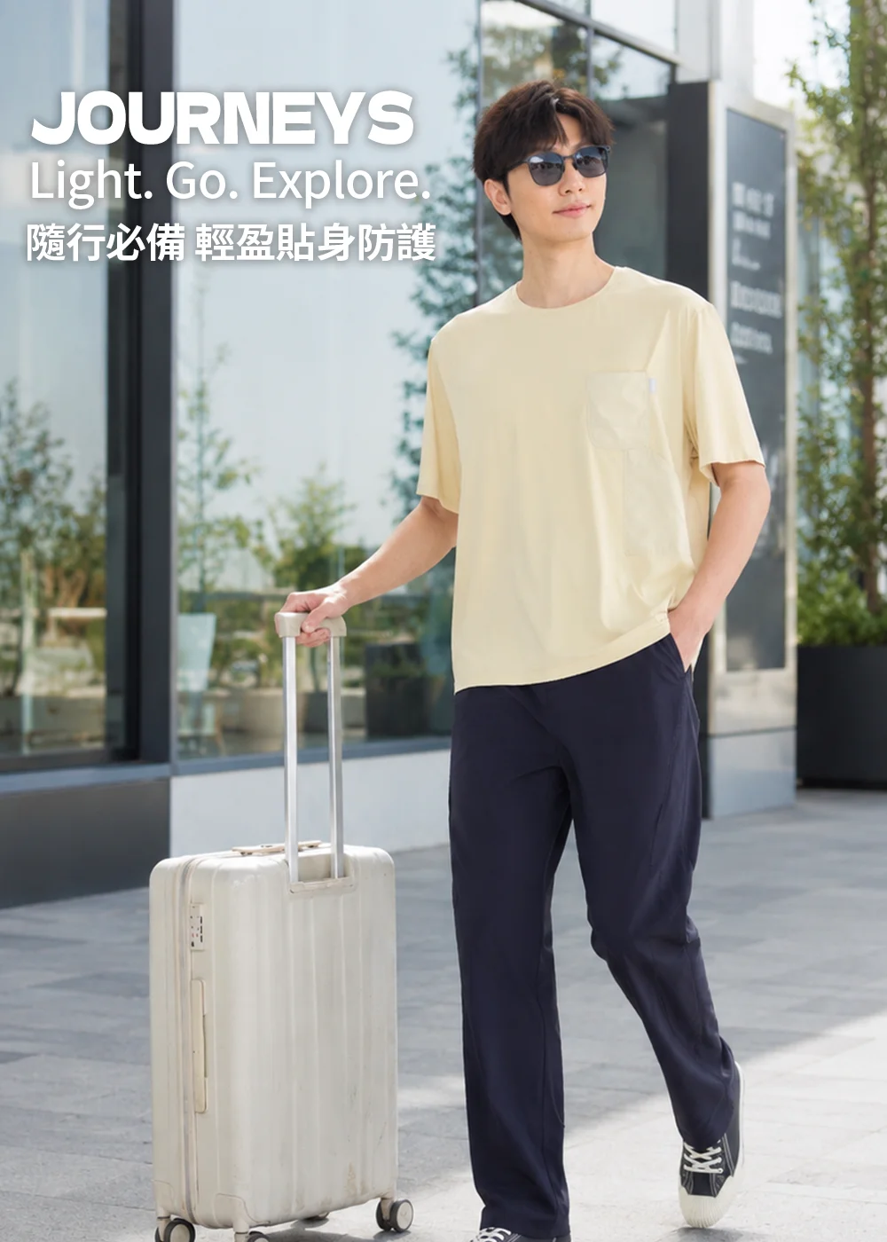 男士旅遊穿搭:配戴UV100黑色方框偏光太陽眼鏡搭配休閒服飾與行李箱,強調「輕盈隨身防護」的旅遊特性。