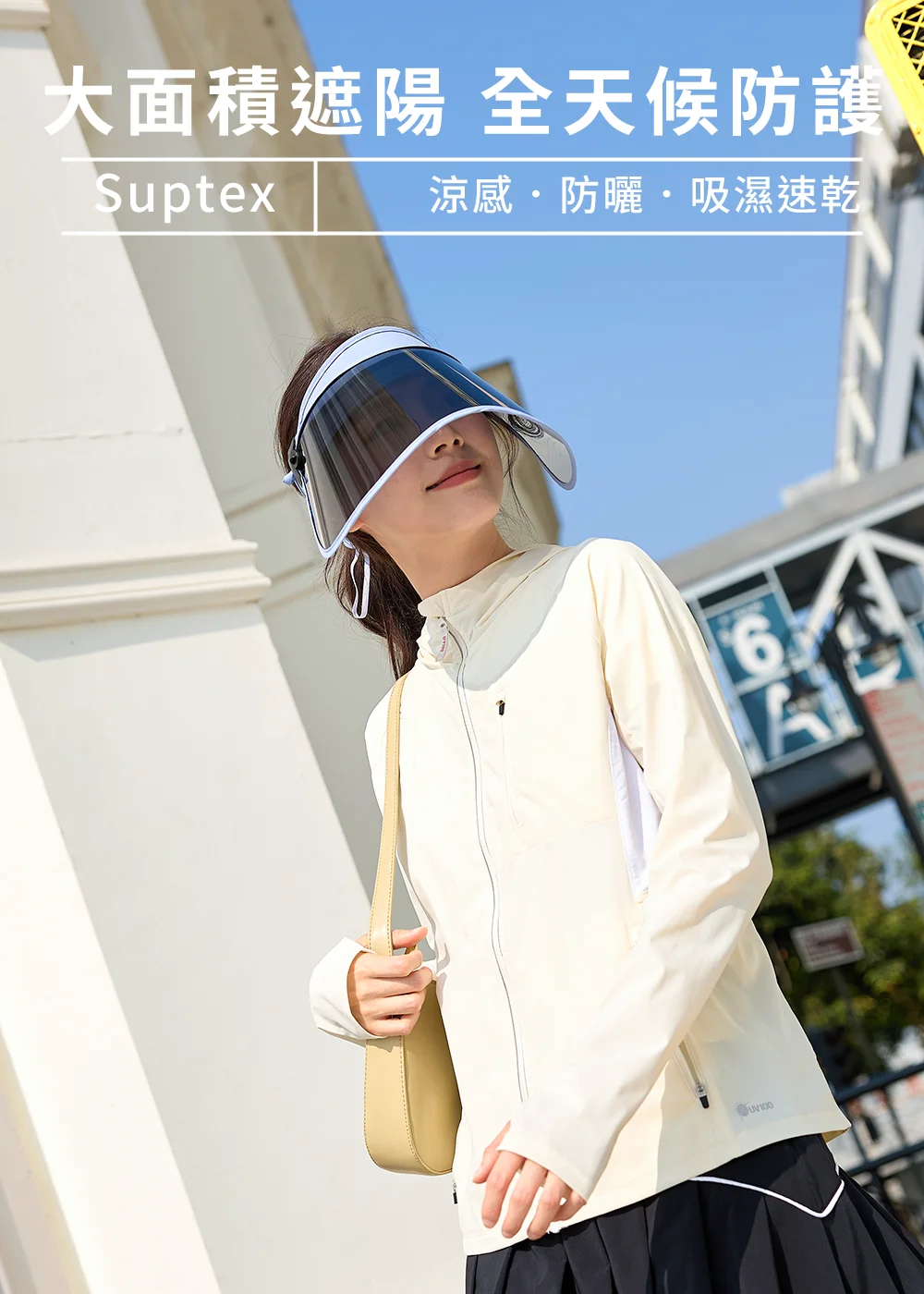 女生戴著UV100抗UV-Suptex清涼遮陽摺收美容面罩帽,搭配米白色防曬外套與黑色百褶裙,大面積遮陽設計提供全臉防曬與全天候物理防護。