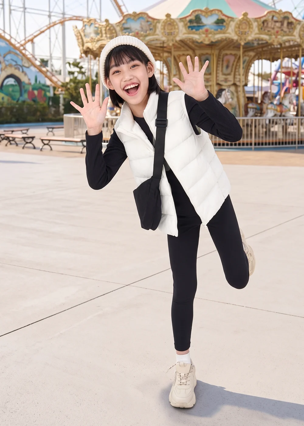 女童戶外防寒穿搭、遊樂園穿搭:女孩於遊樂園穿著黑色發熱衣、白色羽絨背心與彈性保暖褲