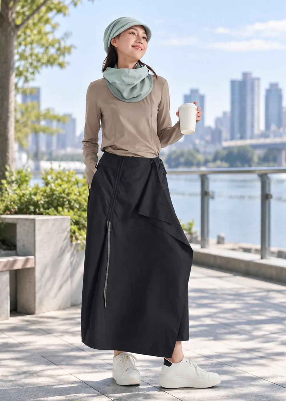女模特兒全身街拍展示秋冬戶外穿搭,配戴淡綠色防風圍脖、休閒長裙與休閒鞋