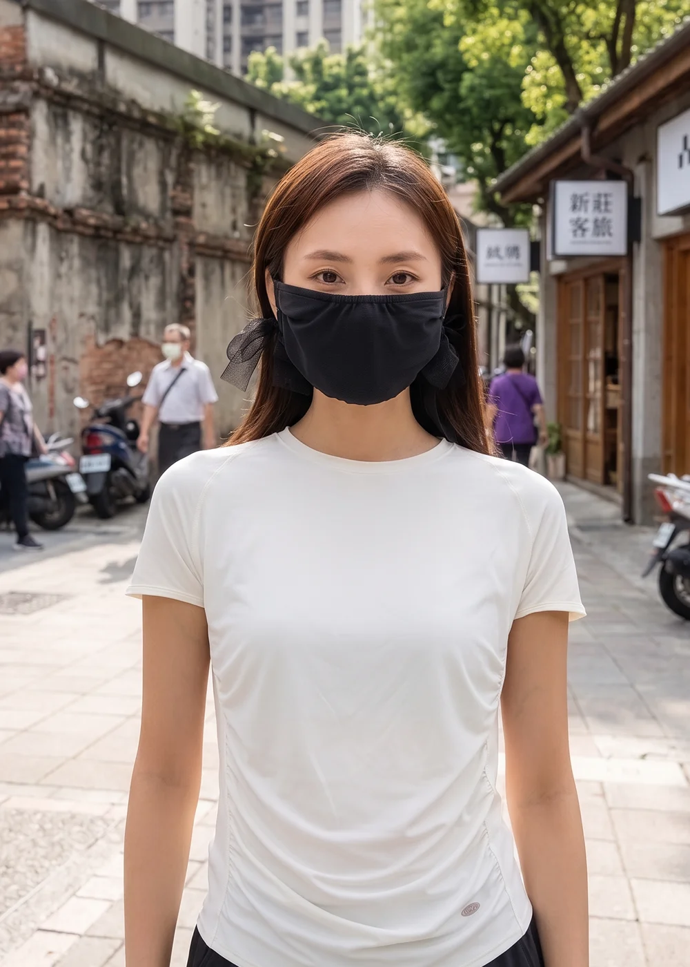 模特兒配戴黑色紗帶蝴蝶結防曬口罩,身穿白色修身短袖上衣,站立於新莊老街戶外場景。