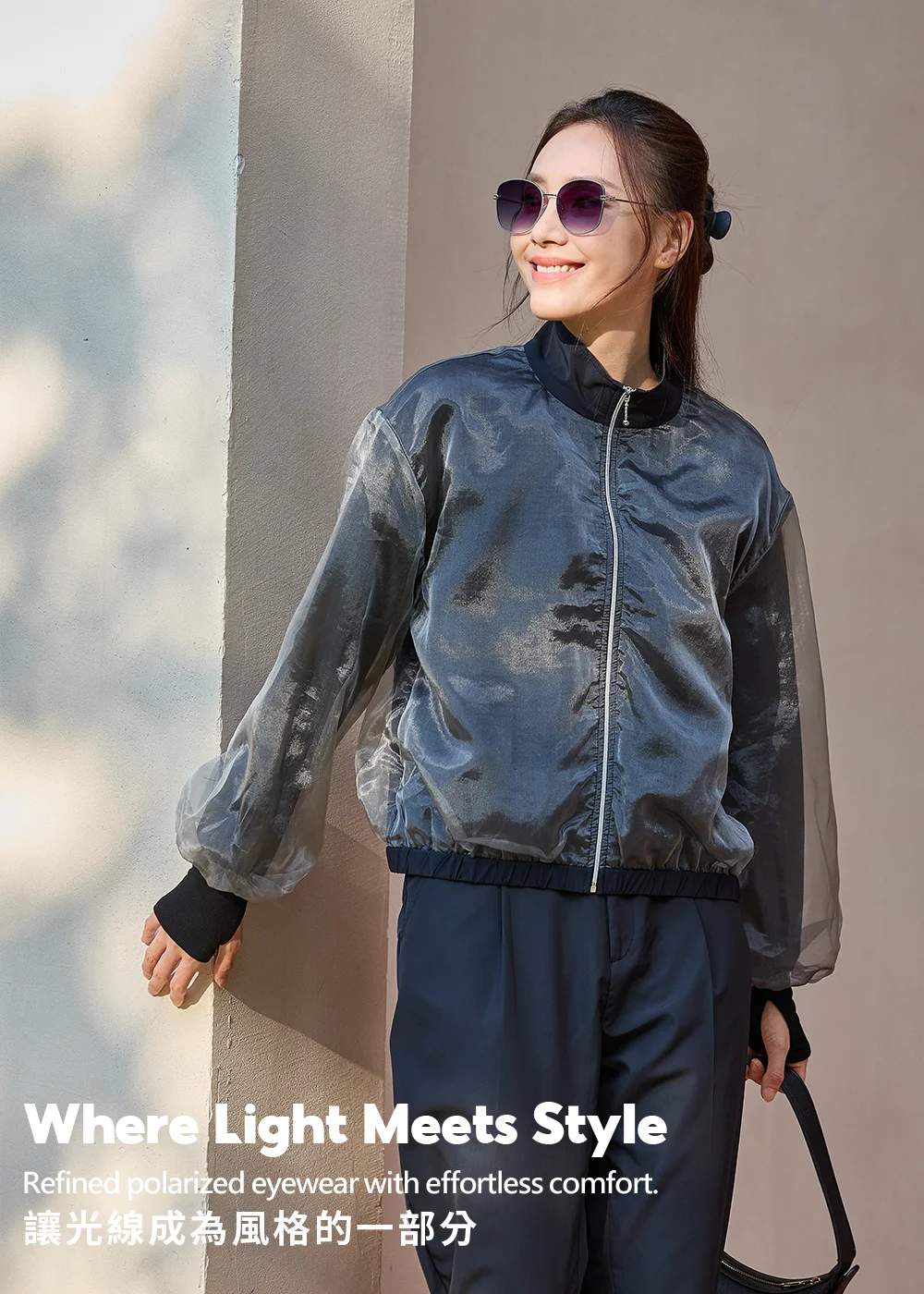 UV100時尚偏光墨鏡細節:女性在陽光下展示細框大鏡面太陽眼鏡,鏡片具備有效過濾眩光功能,讓光線成為風格的一部分。