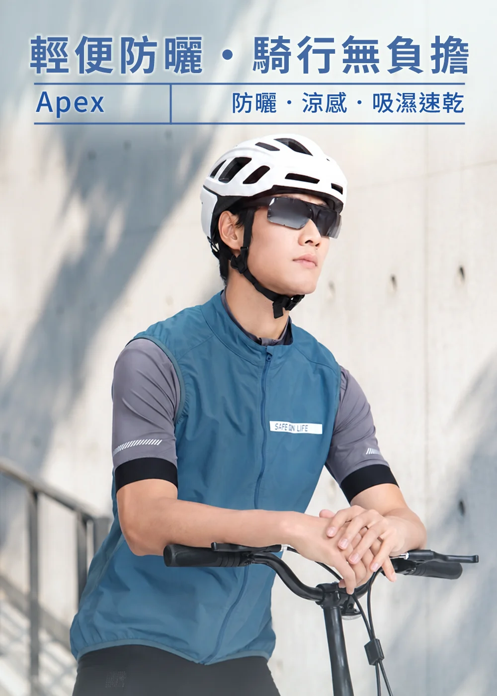 UV100抗UV-Apex涼感速乾防潑自行車背心男款暮藍色。模特兒配戴白色單車安全帽與太陽眼鏡，雙手靠在單車把手。展示背心的高防曬、涼感、吸濕速乾機能，以及正面醒目的反光條安全設計與微立領護頸造型。