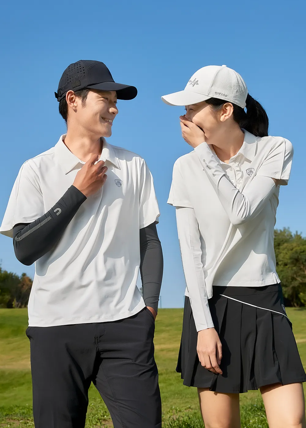 戶外休閒運動穿著白色吸濕排汗高爾夫球衫與防曬手臂套的男女模特兒