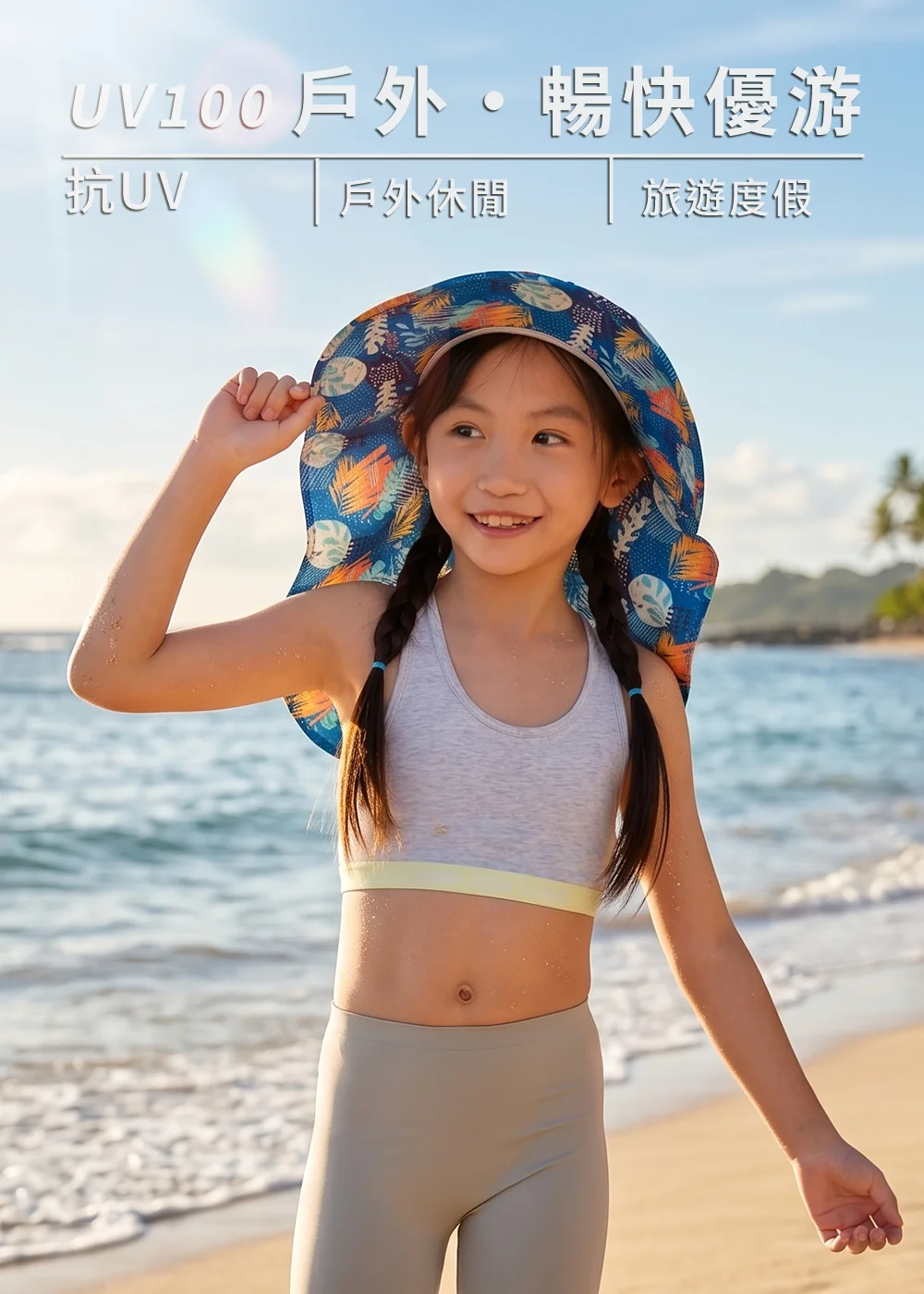 兒童抗 UV 機能防曬帽，小女孩身穿兩截式泳裝、頭戴藍色熱帶植物印花大沿護頸遮陽帽，在夏日海灘旁開心戲水，展現兒童戶外休閒與旅遊度假的暢快優游穿搭。