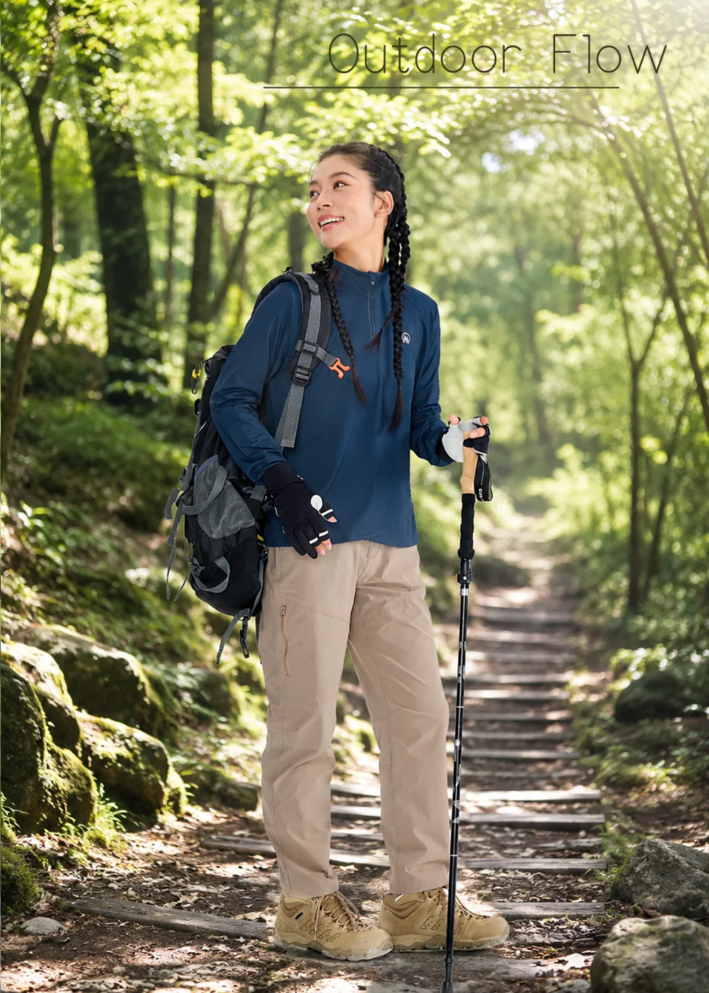 女性背著雙肩登山包、手持登山杖，深藍色女款抗UV長袖防曬上衣，銀纖維抗菌吸濕速乾布料，適合登山健行與森林戶外活動。