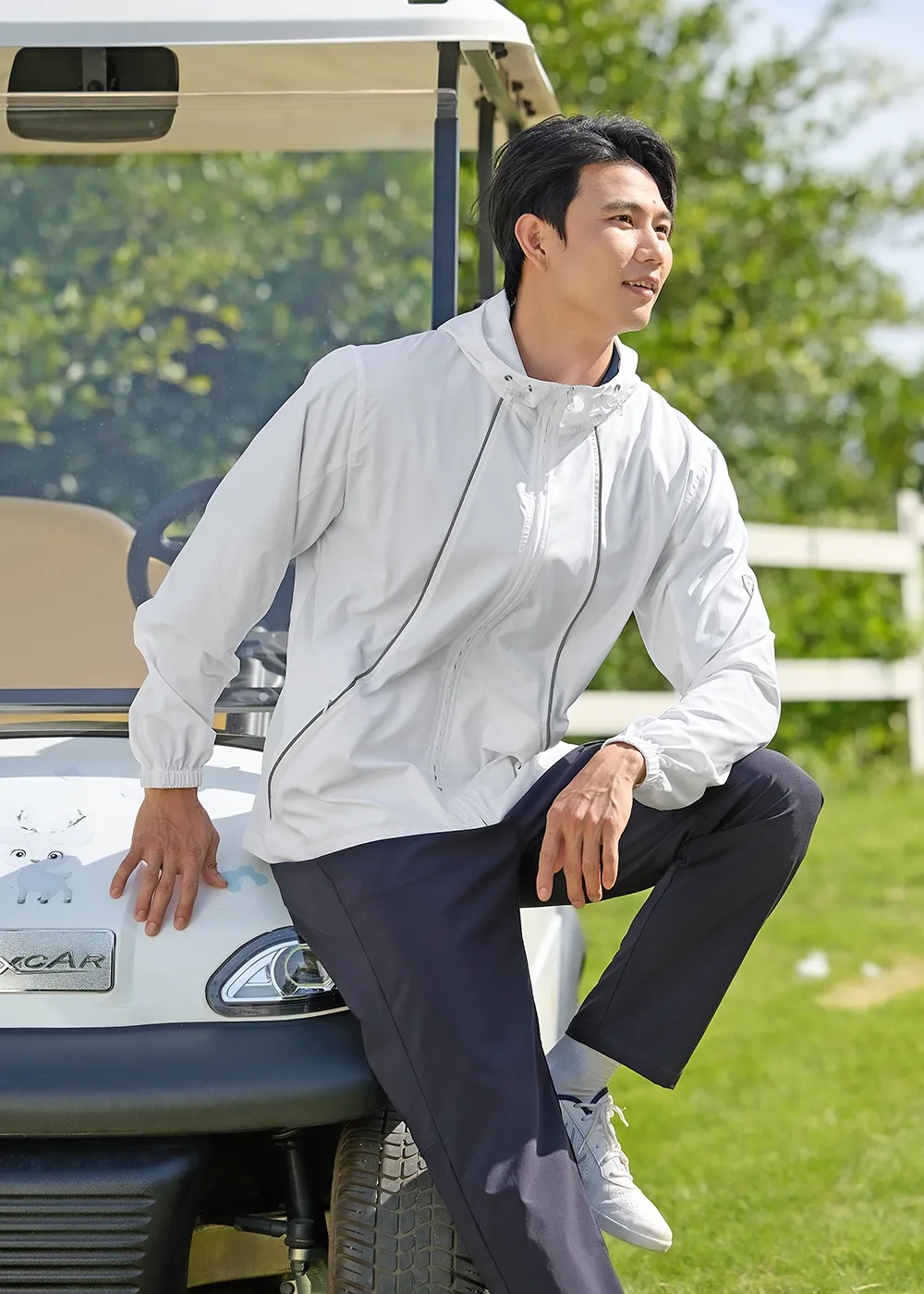SUPTEX男士戶外運動防曬衣，白色涼感防曬連帽外套與高爾夫球車合影，展現休閒時尚風格