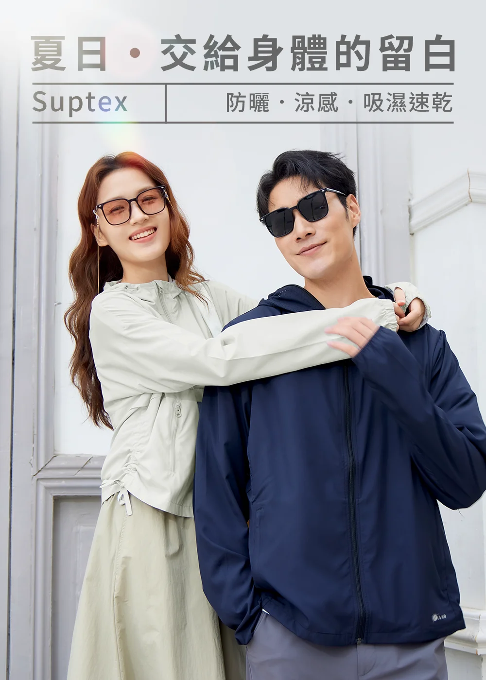 UV100 Suptex 機能防曬外套情侶穿搭，上方標題「夏日・交給身體的留白」，展現防曬、涼感、吸濕速乾特性。女模特兒身穿淺灰色連帽防曬外套戴墨鏡，從後方環抱身穿深藍色防曬外套的男模特兒。