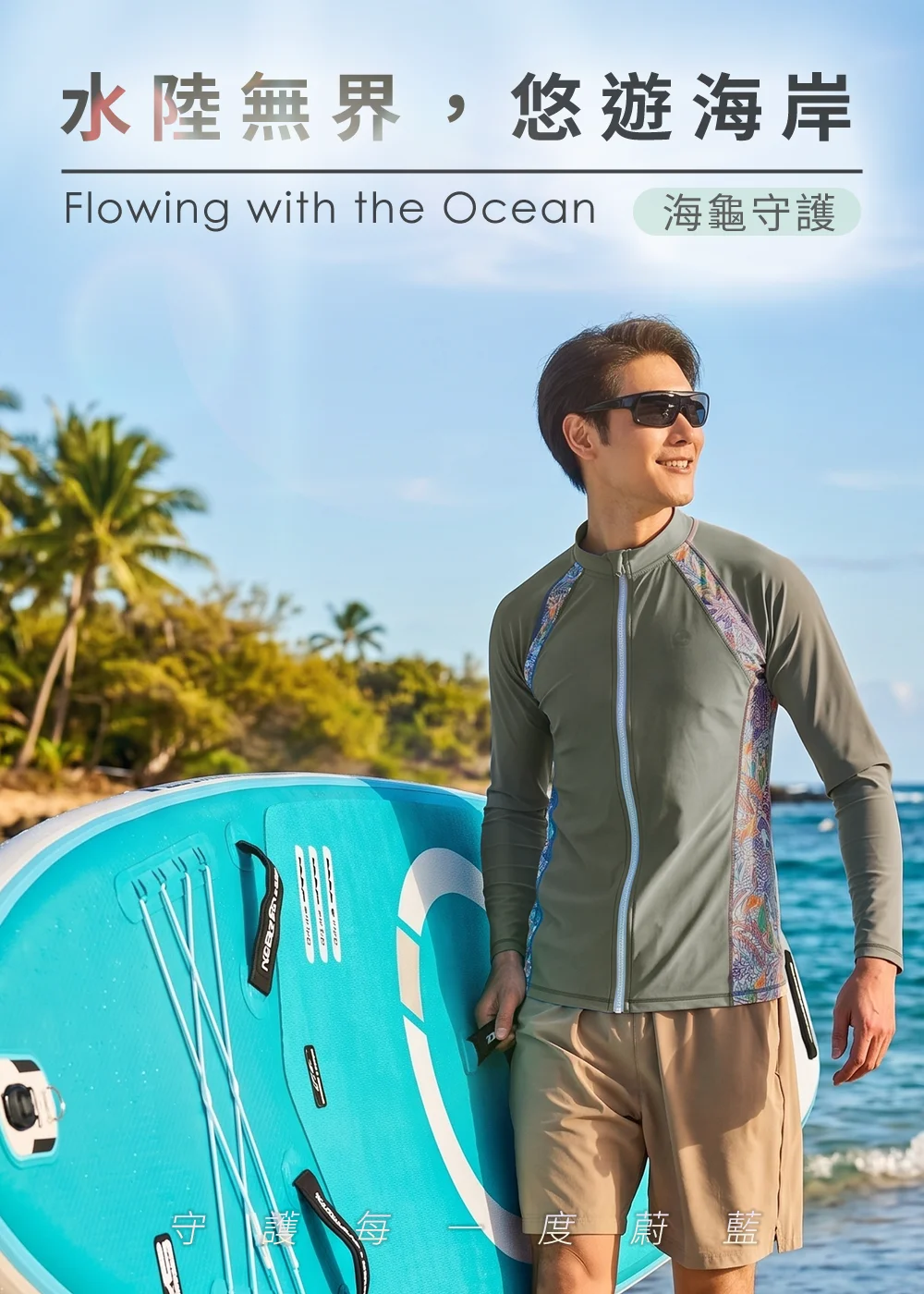 男模特兒配戴太陽眼鏡，身穿綠灰色UV100海龜守護聯名款長袖防曬水母衣與卡其色海灘褲，在陽光椰林海岸旁單手抱著蒂芬妮藍色SUP立槳衝浪板，展現水陸無界、悠遊海岸的防曬涼感穿搭