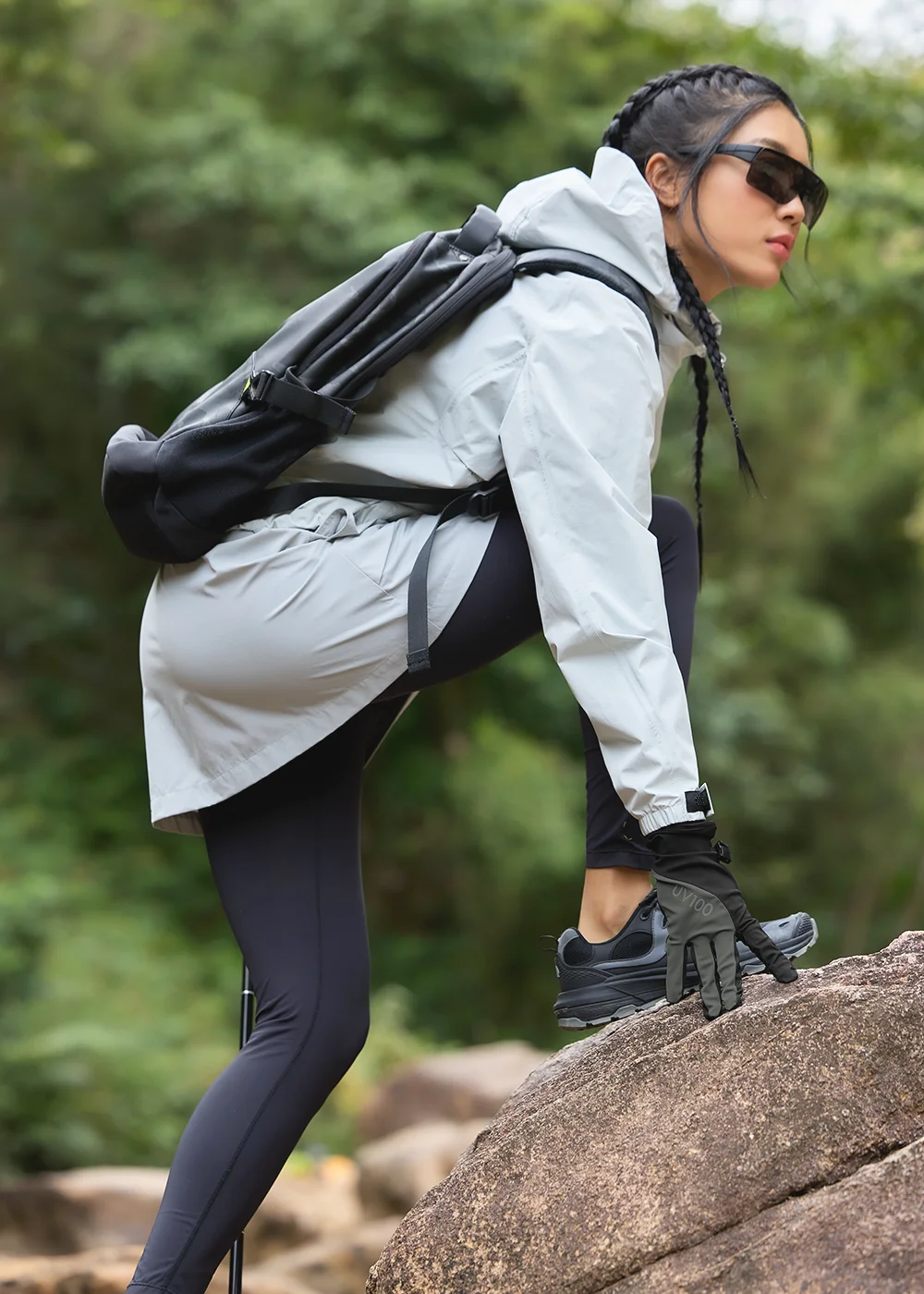 越野登山者配戴 UV100 指尖靈活防曬手套進行岩石攀爬，展現極佳的抓地力與透氣感。