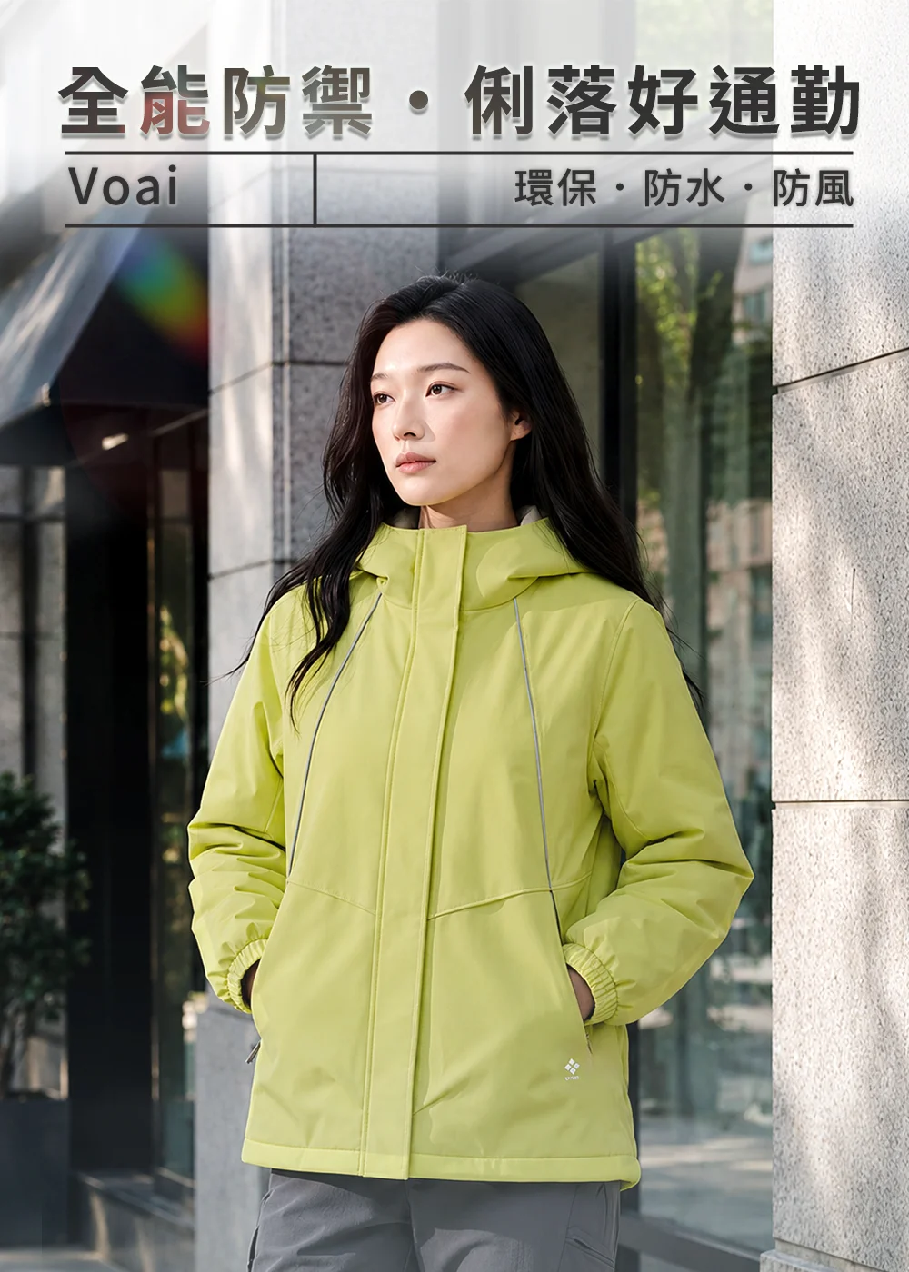 UV100防水環保磁吸擋風連帽外套女款奶香綠。模特兒在城市街頭展示全能防禦與俐落好通勤機能，呈現防水透濕環保平織布全防水工藝、前胸反光剪接設計、防風高領與袖口鬆緊細節。