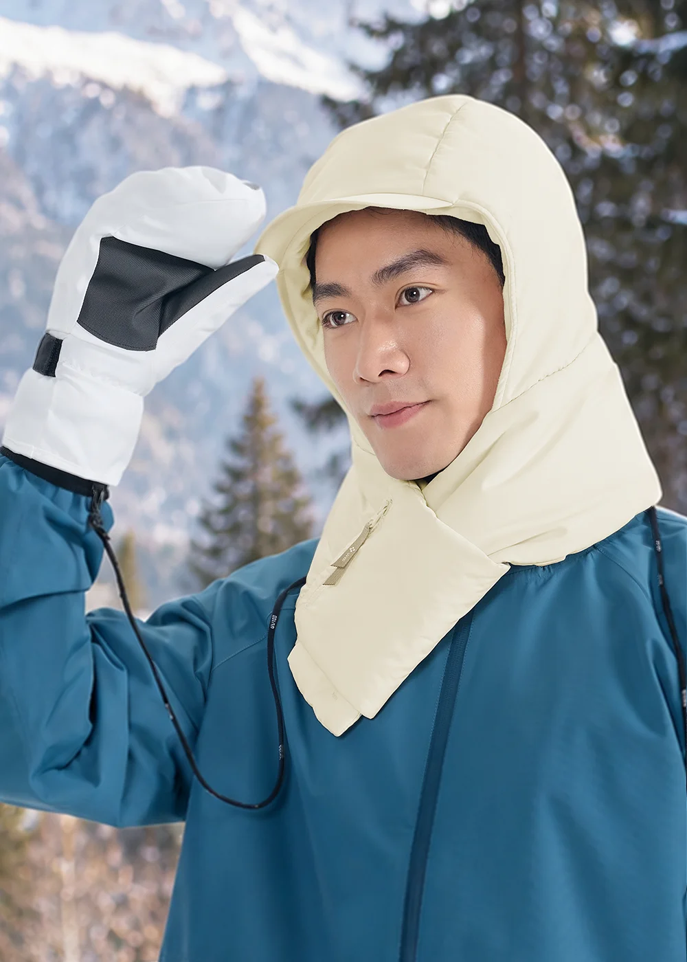 男性佩戴米白色防風防潑水連帽圍巾與防水手套，適合雪地與冬季戶外運動