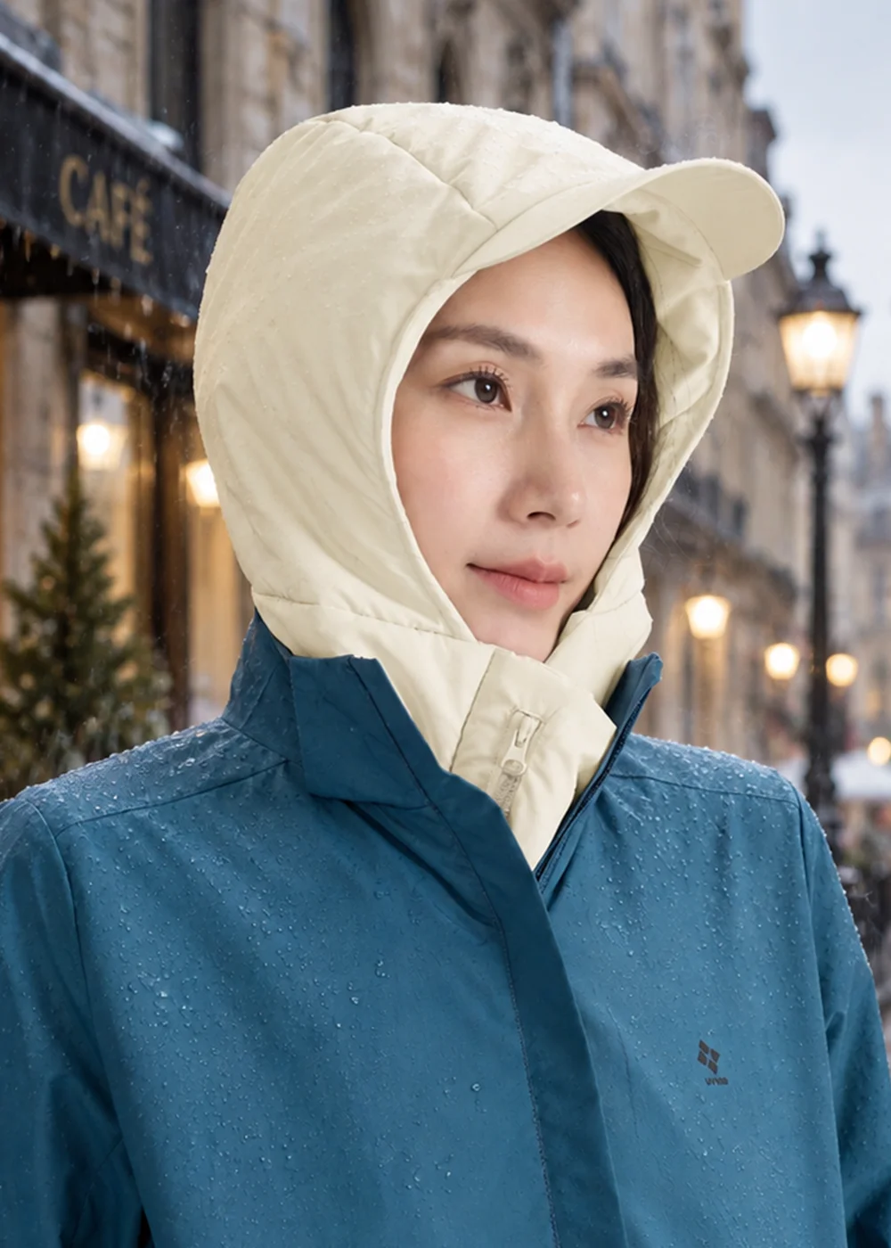 在下雪街道佩戴米色防潑水連帽保暖帽，展現優異的防風禦寒與防潑水面料