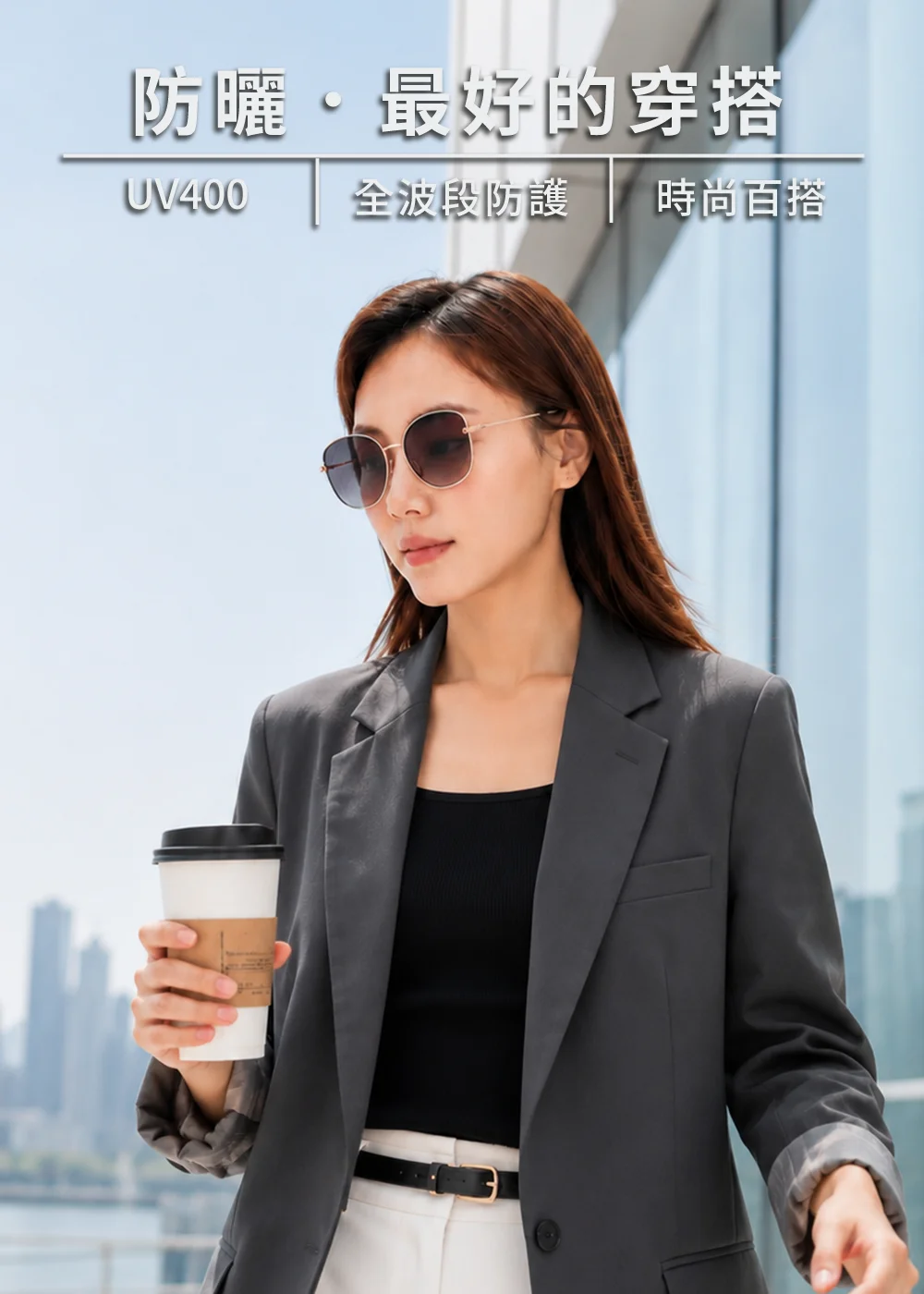 時尚女性配戴UV100大框墨鏡搭配深灰色西裝外套與咖啡，展現都會商務穿搭風與 UV400 防護機能。